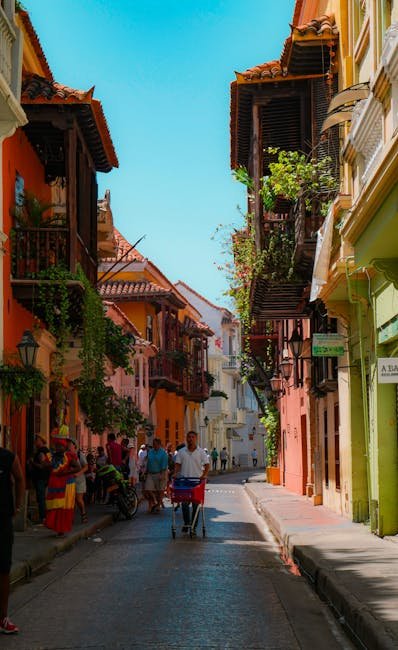 People Walking on Street Between Houses