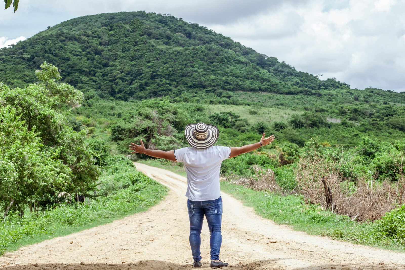 Photo of Man Wearing Hat While Standing on Dirt Road
